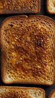 A close up of crispy, slightly burnt toast with rich brown textures. photo