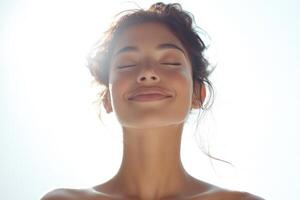 A woman with her eyes closed and smiling photo