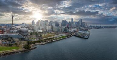 Aerial view of downtown Seattle, Washington, featuring the Space Needle, modern skyscrapers, waterfront, and a cargo ship in the bay under a dramatic sky. photo