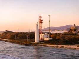 Sunset View of Lighthouse and Red Tower on Oahu Island Coastline photo