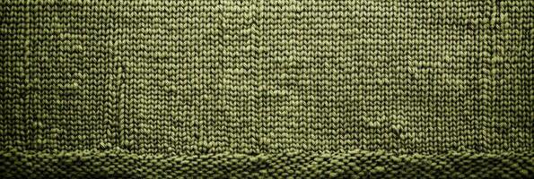 Closeup of green knitted fabric with textured pattern and detailed stitches photo