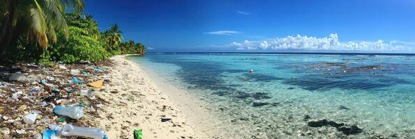 Polluted tropical beach with litter and clear blue ocean on sunny day photo