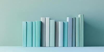 Colorful row of mint green and turquoise hardcover books against a matching backdrop photo