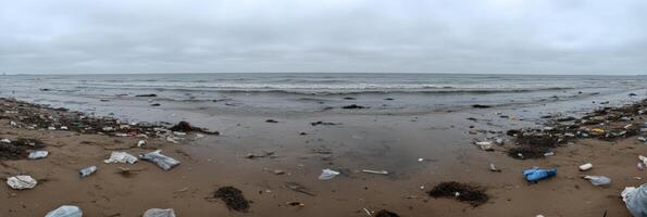 Polluted ocean shore with debris and plastic waste highlighting environmental issue photo