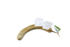 9. A chunk of alum is placed atop a ripe sour tamarind on a white background. This composition highlights the significance of natural elements in traditional medicine, cleansing, and food preparation. photo