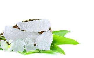 3. Pieces of alum stone on green leaf on white background. This image emphasizes the connection between natural minerals and plant based ingredients in traditional practices and holistic wellness. photo