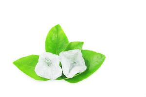 9. Piece of alum stone on green leaf against white background. This image emphasizes the connection between natural minerals and plant based ingredients in traditional practices and holistic wellness. photo