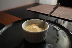 Fresh butter in a white container with a metal spatula photo