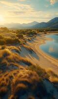 Golden hour illuminates a tranquil landscape of serene beach meeting lake, framed by mountains photo