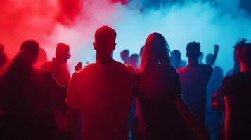 Captivating crowd immersed in vibrant red and blue lighting at an electrifying concert event photo