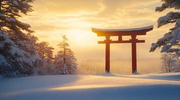 Serene japanese torii gate standing silhouetted against a snowy landscape at golden sunrise photo