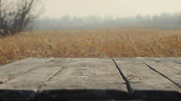 Rustic wooden table against blurred wheat field, vintage countryside scenic view photo