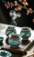 Steaming tea in exquisite turquoise cups showcases oriental charm with floral motif and dark backdrop photo