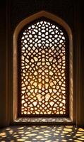 Intricate window lattice casting dappled light patterns on the floor of a historical building photo