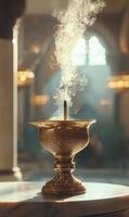 Ornate golden incense burner emitting swirling smoke in a softly lit interior space photo