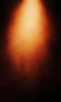 Ethereal glow emanates from above, casting warm amber tones across a textured dark backdrop photo