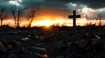 A cross stands in the middle of a field at sunset photo