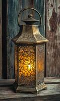 Ornamental lantern casting warm light, vintage metal decoration on rustic wooden surface photo
