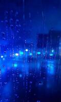 Electric twilight behind rain streaked window, cobalt blurred city lights through condensation photo