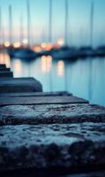 Serene twilight waterscape with stone steps leading towards blurred sailboats at harbor photo