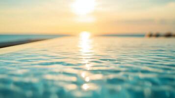 Serene infinity pool edge reflecting soft sunset light and sea horizon in tranquil water photo