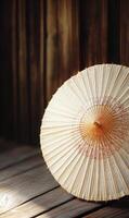 Artisan paper parasol casting gentle shadows on aged wooden boards in tranquil ambiance photo
