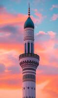 Omani Mosque Minaret Illuminated by a Dramatic Sunset Sky in Vibrant Tones and Intricate Design photo
