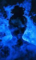 Silhouette of a woman engulfed in a captivating blue smoke filled ambiance artwork style photo