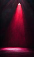 Illuminated stage with a singular red spotlight piercing through atmospheric haze and darkness photo