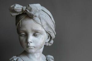 A statue of a young girl with a bow on her head photo