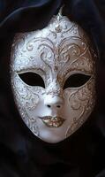 Elegant venetian mask with intricate silver designs displayed on a black background photo