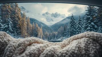 Pristine white blanket inside car frames snowy mountain vista through window, contrasting warm interior with winter pine forest and misty peak landscape. calm photo