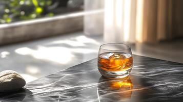Refined whiskey glass sits atop black marble table, golden liquid catching natural sunlight with dramatic shadow play, creating luxurious drink presentation. glass photo