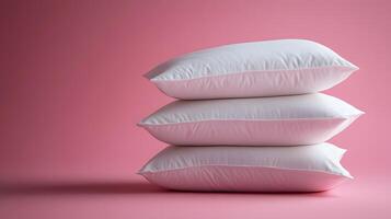 Pure white fluffy pillows stacked against soft pink background create minimalist composition with right-side positioning, emphasizing textile textures and comfort. pillows photo