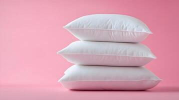 Pure white fluffy pillows stacked against soft pink background create minimalist composition with right-side positioning, emphasizing textile textures and comfort. textile photo