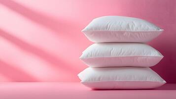 Pure white fluffy pillows stacked against soft pink background create minimalist composition with right-side positioning, emphasizing textile textures and comfort. soft photo