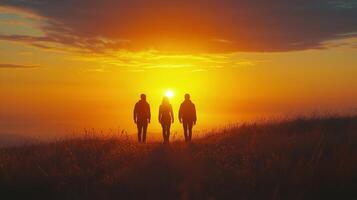 Friends enjoying a sunset view on a hilltop against a vibrant orange sky. photo