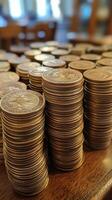 Stacked coins creating a large display on a wooden table during daylight hours. photo