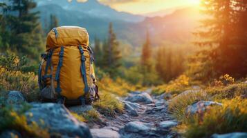 Backpack resting on a hiking trail at sunset in a mountainous landscape. photo