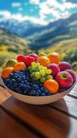 Fresh fruit bowl displayed against a stunning mountain landscape during daylight. photo