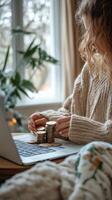 Woman counting coins by laptop in a cozy indoor space during daytime. photo