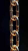 Golden chain links shining against a black background highlighting textured details. photo