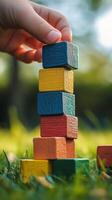 Stacking colorful wooden blocks on a sunny day in a garden. photo