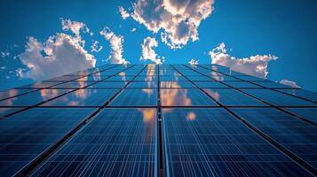 Solar panels reflect clouds and blue sky at a renewable energy facility. photo