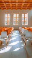 Rows of empty chairs in a bright room with large windows during the day. photo