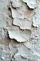 Detailed view of a textured wall revealing peeling paint and cracks in a rustic atmosphere. photo