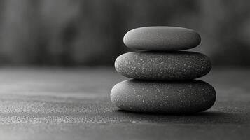 Stacked smooth stones in calming arrangement on a textured surface in monochrome. photo