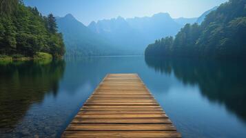 Wooden dock extending into a serene lake surrounded by mountains in the early morning light. photo