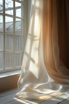Soft curtains gently sway in sunlight by a window illuminating a serene indoor space during morning. photo