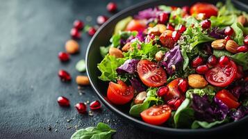 Fresh colorful salad with pomegranate seeds and almonds on a dark background. photo